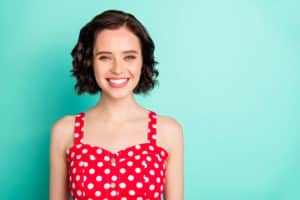 Close up portrait of fascinating young, beautiful wonderful lady posing in front of came while isolated with teal background | smile makeover